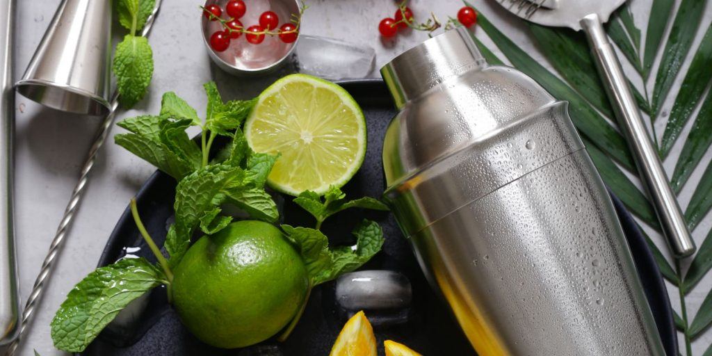 Close overhead shot of cocktail shaker with citrus and mint