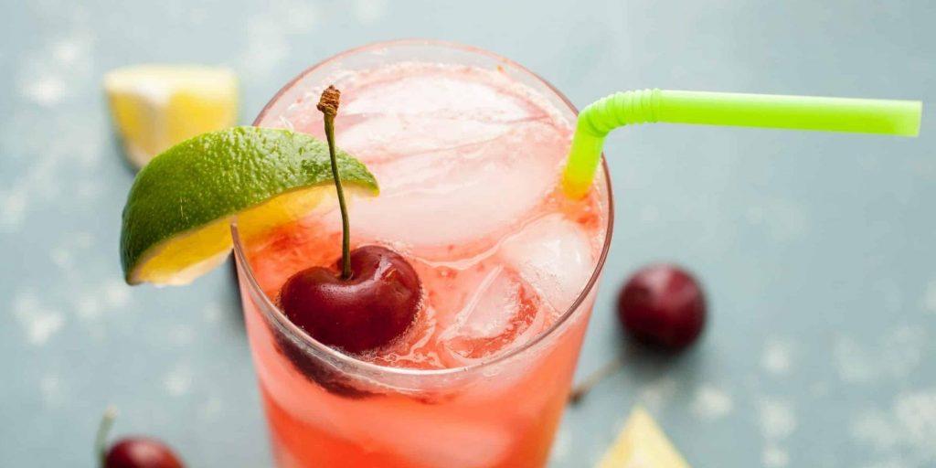 Top view of a Cherry LIme Rickey mocktail garnished with a lime wedge and a fresh cherry