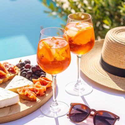 cocktails by the pool with cheese board, hat and sunglasses