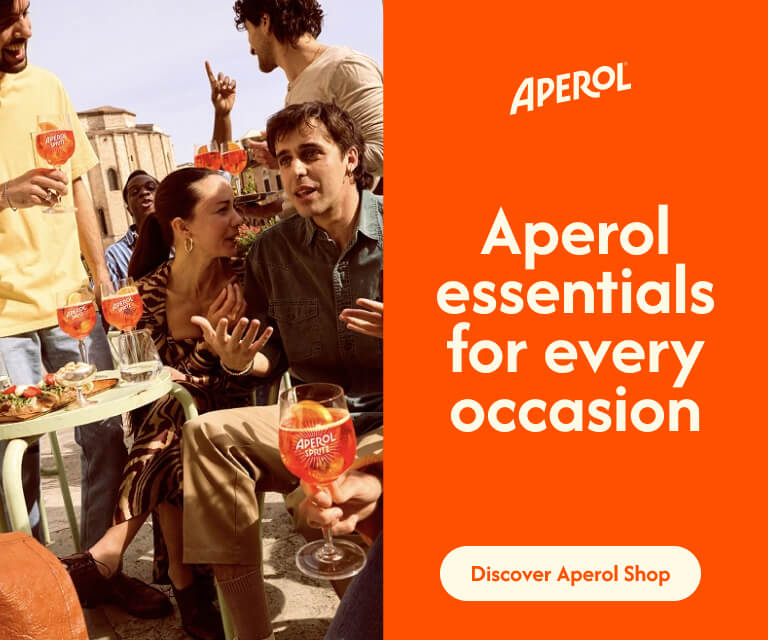 A group of friends chatting and toasting with Aperol Spritz glasses in a sunny, relaxed setting. Text on the image: “Aperol essentials for every occasion. Discover Aperol Shop.”