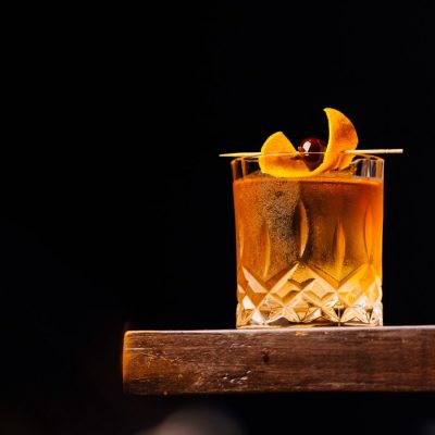 A close up shot of a bourbon Old Fashioned on a wooden counter