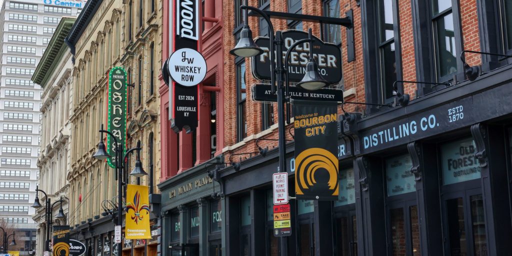 City buildings and distillery street signs on a road in Louisville on the Kentucky Bourbon Trail.