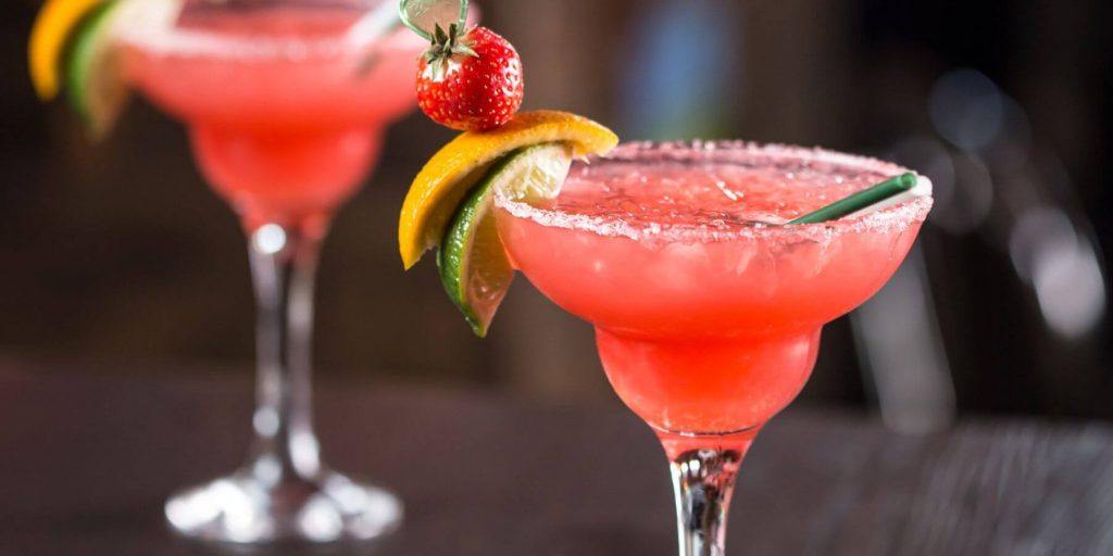 A vibrant Strawberry Lime Smash cocktail garnished with fresh strawberries and lime slices.