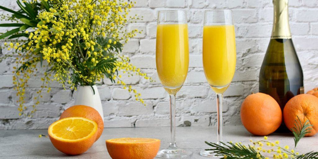Two Mimosa cocktails in flute glasses in a modern kitchen setting