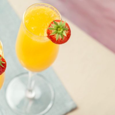 Top view of two Grand Mimosa cocktails with fresh strawberry garnish