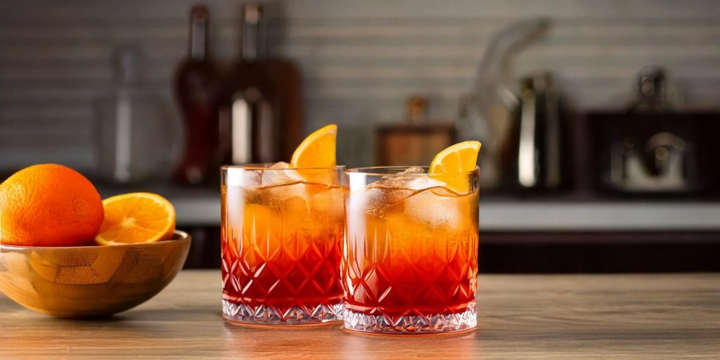 Two Aperol Boulevardier cocktails in a modern kitchen setting
