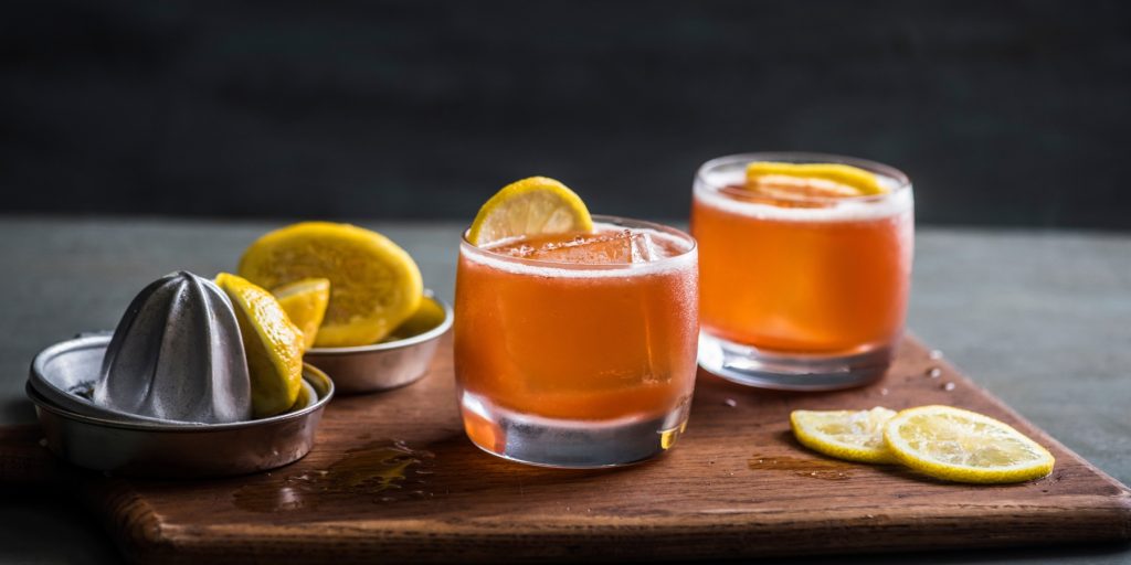 Two Paper Plane bourbon cocktails served in lowball glasses with lemon garnish