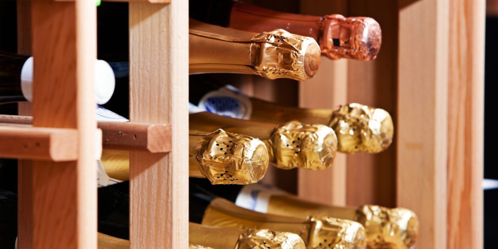 Champagne being stored horizontally in a wooden rack