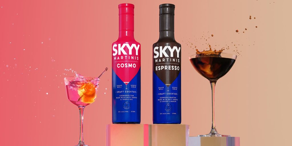 SKYY Cosmo and SKYY Espresso Martini bottles side by side, with their respective cocktails splashing dramatically.