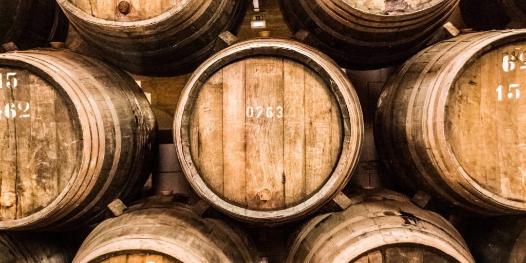 Stacked wooden barrels marked with serial numbers used in solera aging for brandy, photo by Arieleon.photogrophy/Adobe Stock
