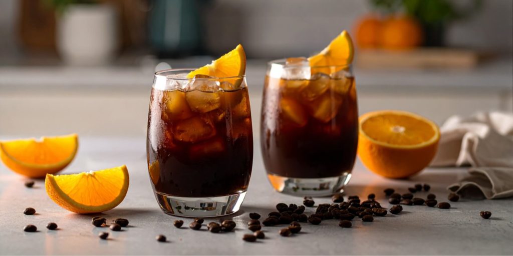 Two Bold Greek Coffee Cocktails with fresh orange wedge garnish