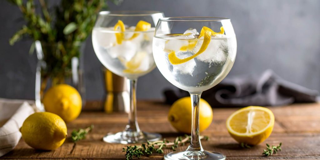 Close-up of two Gin and Tonic cocktails with lemon peel garnish