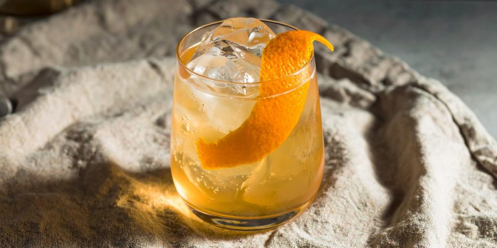 An Expense Account cocktail in a rocks glass, garnished with an orange twist