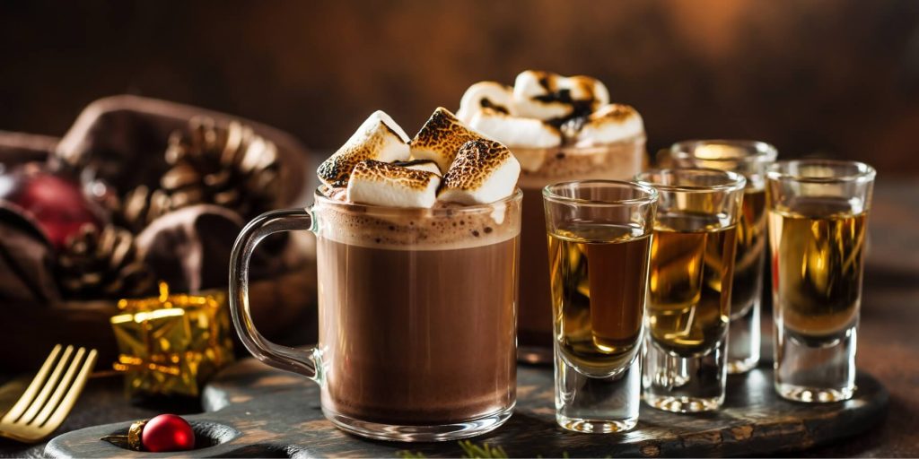 Two glass mugs of tequila hot chocolate with tequila shots