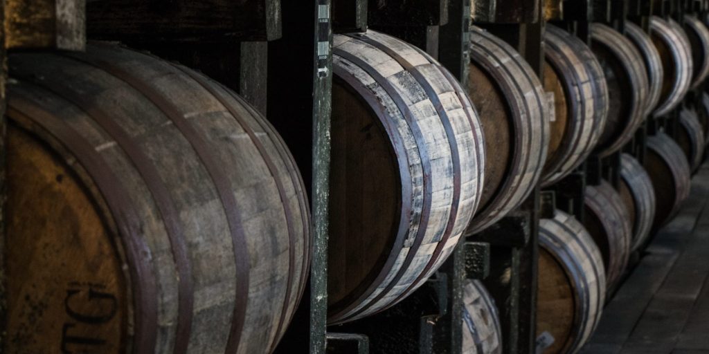 Bourbon barrels resting on racks in a rickhouse